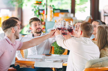 Friends drink wine on the terrace of the restaurant.