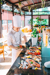 The Chef puts the seafood on a tray in the restaurant.
