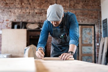 Successful handsome businessman with stylish cap work in carpentry
