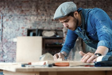 Successful handsome businessman with stylish cap work in carpentry