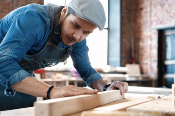 Successful handsome businessman with stylish cap work in carpentry