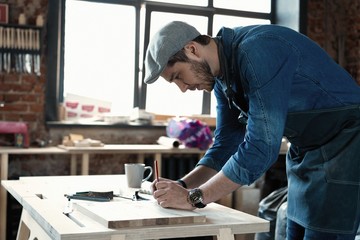 Successful handsome businessman with stylish cap work in carpentry