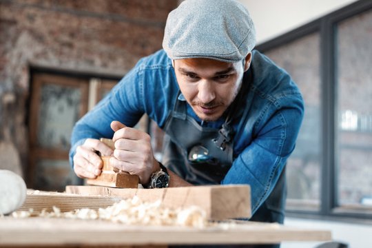 Successful handsome businessman with stylish cap work in carpentry