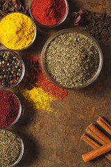 Fototapeta premium Dried Marjoram . Place for text. Different types of Spices in a bowl on a stone background. The view from the top