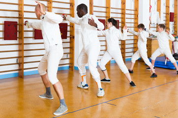 Ordinary group of athletes at fencing workout