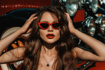 Outdoor close up portrait of young beautiful elegant woman with long luxury hair, red lips makeup,...