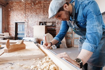 Successful handsome businessman with stylish cap work in carpentry