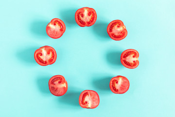 Tomato pattern. Frame made of fresh half tomatoes on light blue background. Flat lay, top view, copy space