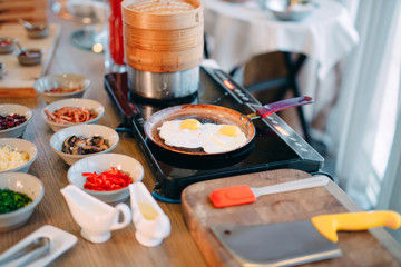 Breakfast. Scrambled eggs are cooked on an induction cooker in the restaurant.