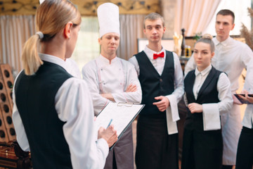 restaurant manager and his staff in kitchen. interacting to head chef in commercial kitchen.