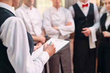 restaurant manager and his staff in kitchen. interacting to head chef in commercial kitchen.