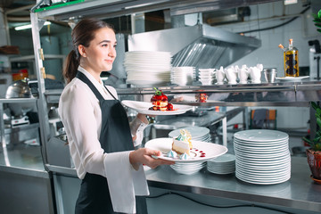 Waiter serving in motion on duty in restaurant. The waiter carries dishes.