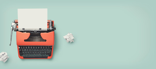 retro banner with red vintage typewriter with a blank sheet of paper and paper balls, top view, copyspace - obrazy, fototapety, plakaty