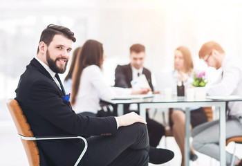 Manager of the company on the background of the working meeting the business team