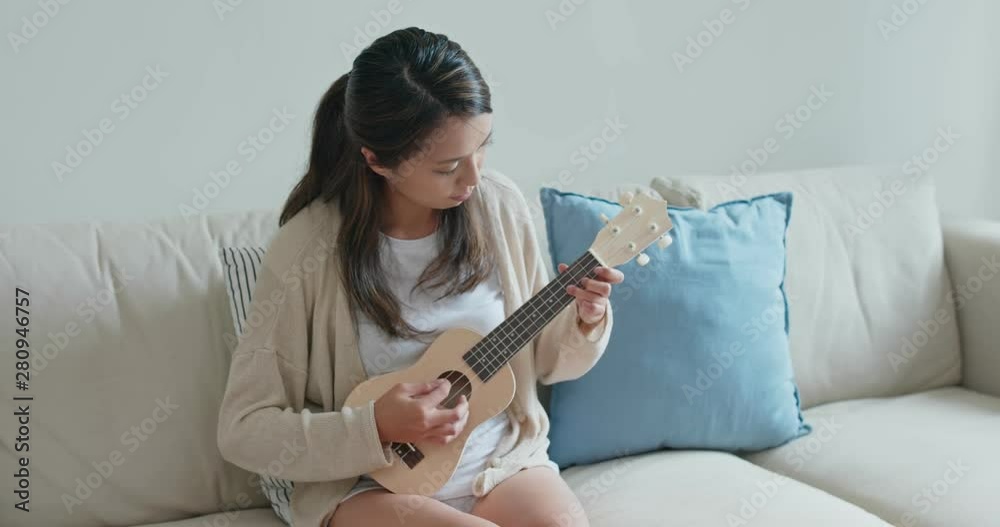 Canvas Prints Woman play ukulele at home