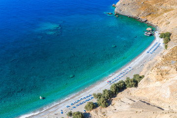 Aerial view of Glyka Nera beach (Sweet Water or Fresh Water). View of the remote and famous Sweet Water Beach in south Crete, with its unique tavern on the rock inside sea. This is a nudist beach.