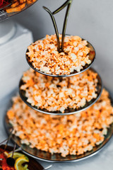 A close-up of salty popcorn on a metal multilevel stand. wedding