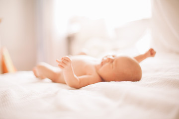 Obraz na płótnie Canvas portrait of a pretty newborn baby lying on the bed. photo with copy space