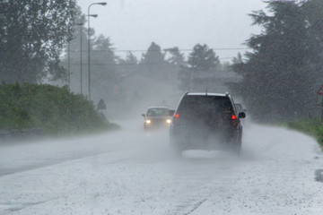 The strong storm with heavy rain on the road with poor visibility of cars. Concept of the danger of...