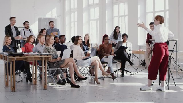 RED EPIC Group of happy multiethnic business people listen to female coach speaking at modern office seminar slow motion
