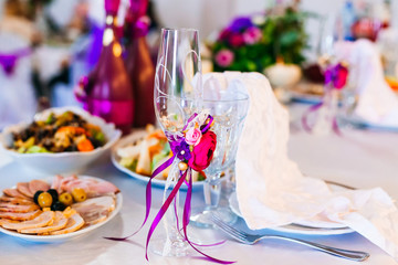 close-up of wineglasses for newlyweds with flowers and ribbons.