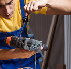 Worker working in repair workshop in woodworking concept