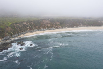 Seen from a bird's eye view, the Pacific Ocean washes against a scenic beach south of Monterey in Northern California. This beautiful area runs parallel to the famed Pacific Coast Highway.