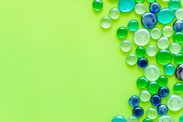 Glass stones for design and home creativity on green background top view space for text