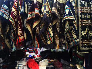 Fototapeta na wymiar A long line of woolen ponchos with typical south american patterns