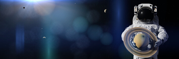 Fototapeta premium astronaut holding planet Saturn, moons orbiting the gas giant