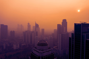 Aerial sunset view of Jakarta city with air pollution