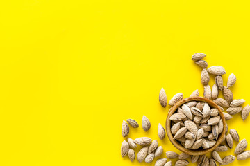Healthy snack with almonds on yellow background top view mock up