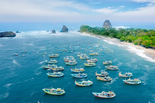 Beautiful Papuma beach with traditional boats