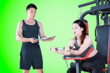 Beautiful woman executes exercise with her trainer