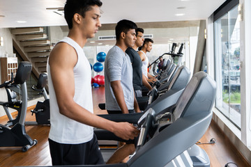 Fototapeta premium group of young people running on treadmills in modern sport gym
