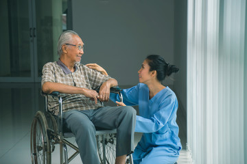 Fototapeta na wymiar Disabled old man talking with his nurse