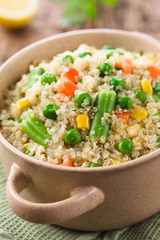 Fresh homemade cooked white quinoa with colorful vegetables (green peas, sweet corn kernels, green beans, carrots) and parsley in bowl (Selective Focus, Focus one third into the dish)