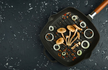 Fresh mushrooms with spices and herbs on black board. View from above. Copy space.