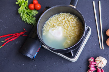 Instant noodles and egg boiling in a pan