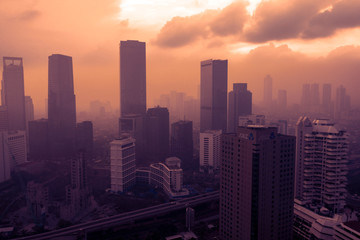 Naklejka na ściany i meble Jakarta city covered by dust smog at sunset