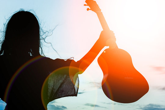 Happy Girl With Ukulele By The Sea On Nature Silhouette Background