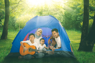 Muslim family with guitars in the camping tent