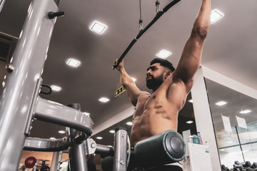 Fit man on lat pulldown machine at the health club. Work out on Pulldown Weight Machine