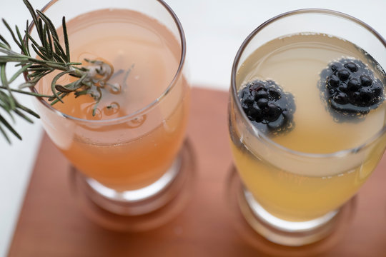 Mimosa Flight With Blackberries, Champagne And Rosemary On A Wood And Marble Background