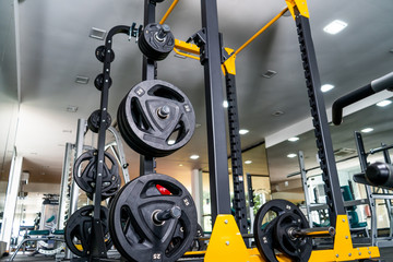 Modern light gym. Sports equipment in gym. Barbells of different weight on rack.