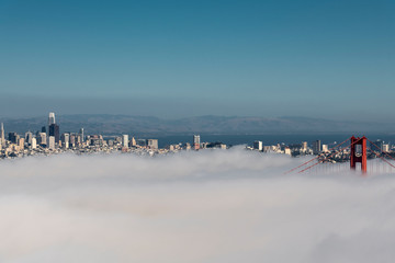 Golden Gate bridge under a bed of fog on a clear day for the city by the bay San francisco - Powered by Adobe