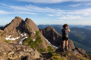 Adventurous girl hiking the beautiful trail in the Canadian Mountain Landscape during a vibrant summer evening. Taken at Mt Arrowsmith, near Nanaimo, Vancouver Island, BC, Canada.