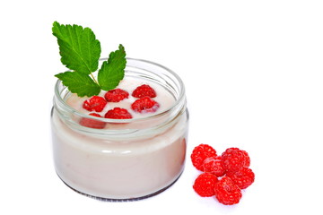 Pink cream or milk fruit yogurt with natural ripe red raspberry berry and green raspberry leaves in open glass transparent jar next heap raspberry on white background. Isolated