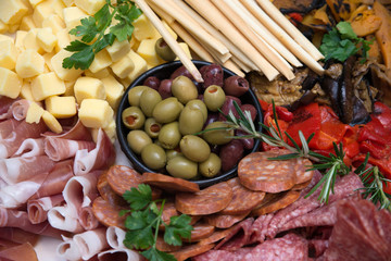 Abstract closeup of antipasti mixed event catering platter with cheese, meet olives and vegetables