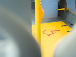 Close-up handicap logo in a bus. Priority seat for disabled people. Wheelchair accessible...